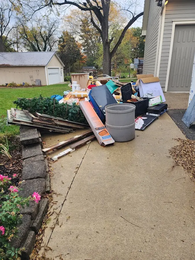 Dumpster being loaded with debris for Estate Cleanout Dumpster Rental in Spring Lake
